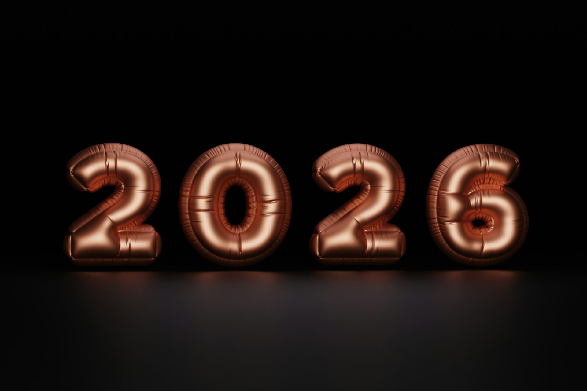 Rose gold balloons spelling out 2026 on black background